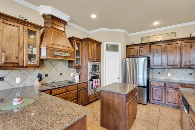 a large kitchen with kitchen island granite countertop a sink and a large window