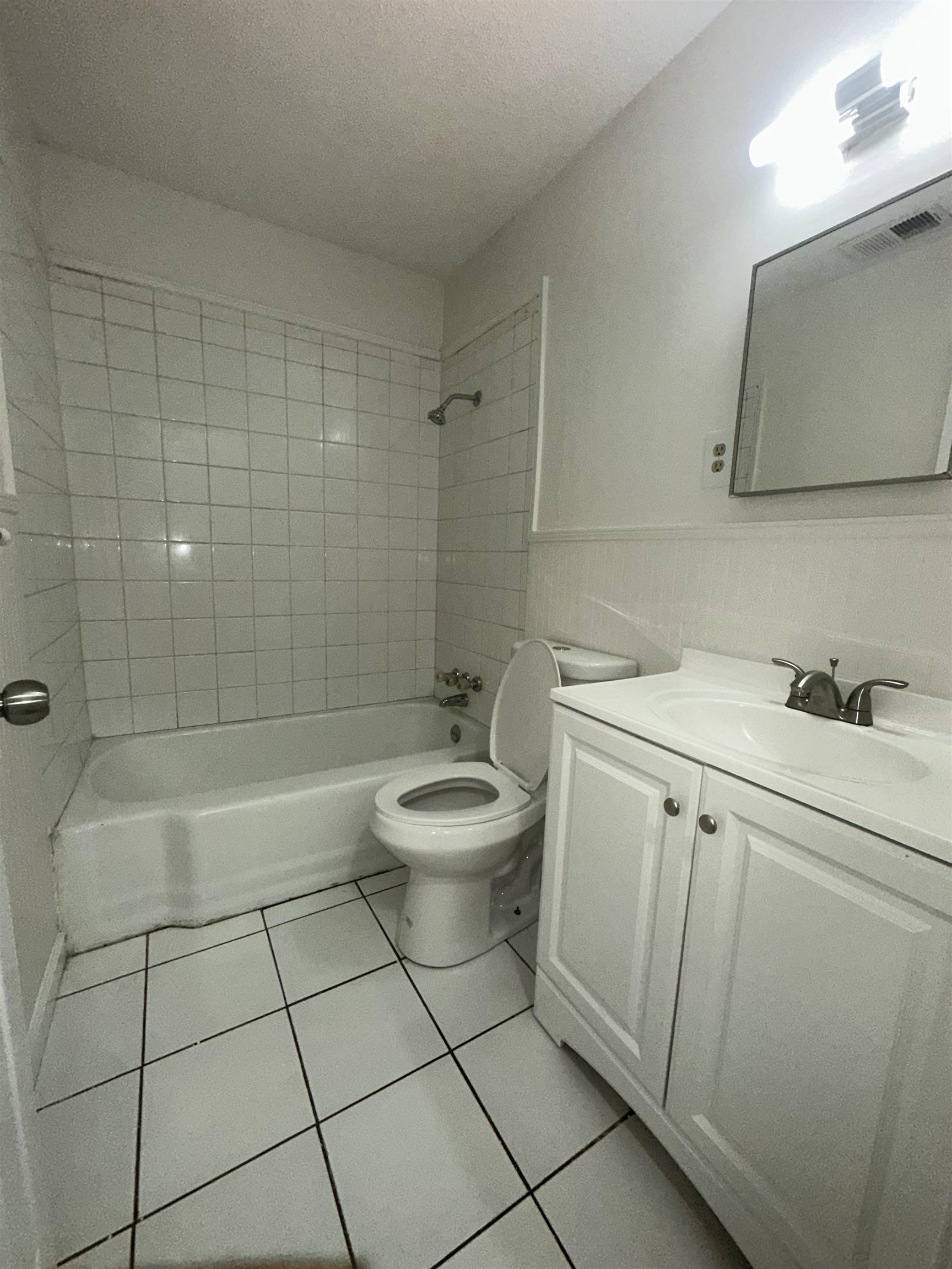 4545 Verne Road Memphis, TN 38117 - Photo 8 of 10 Full bathroom featuring a white tile floor, white tiled shower surround, and a white vanity with an integrated sink and chrome faucet