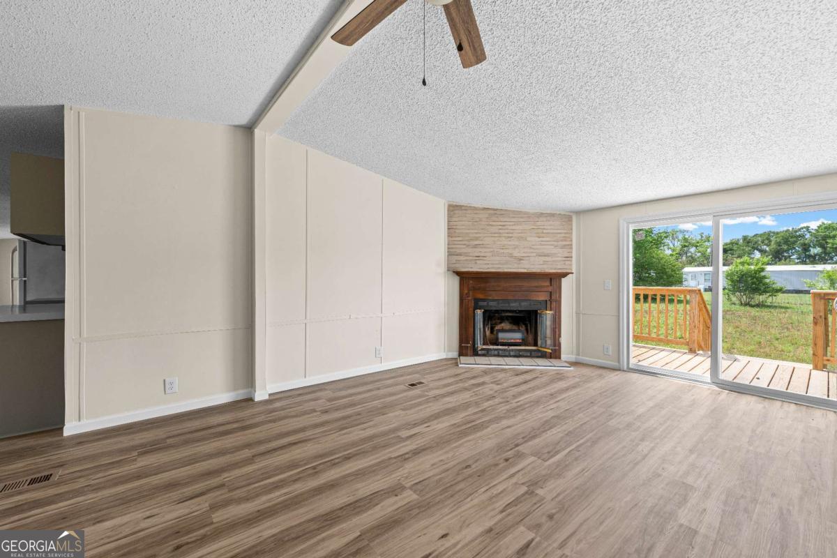 802 Allen Drive Vidalia, GA 30474 - Photo 14 of 29 a view of an empty room with a fireplace and a window