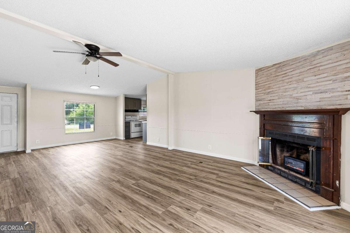 802 Allen Drive Vidalia, GA 30474 - Photo 15 of 29 an empty room with wooden floor fireplace and windows