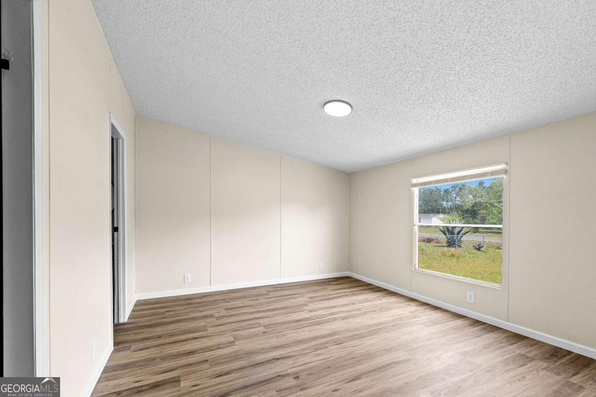 802 Allen Drive Vidalia, GA 30474 - Photo 18 of 29 an empty room with wooden floor and windows