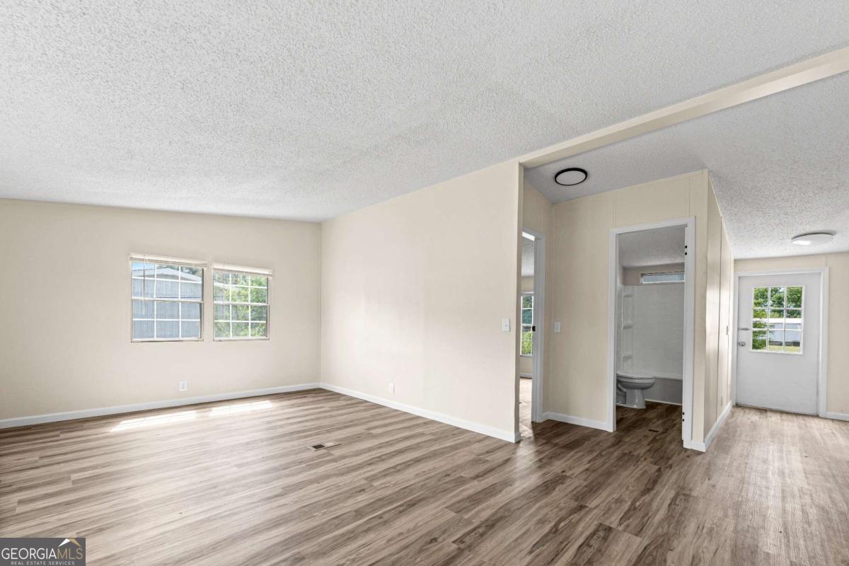 802 Allen Drive Vidalia, GA 30474 - Photo 23 of 29 an empty room with wooden floor and windows