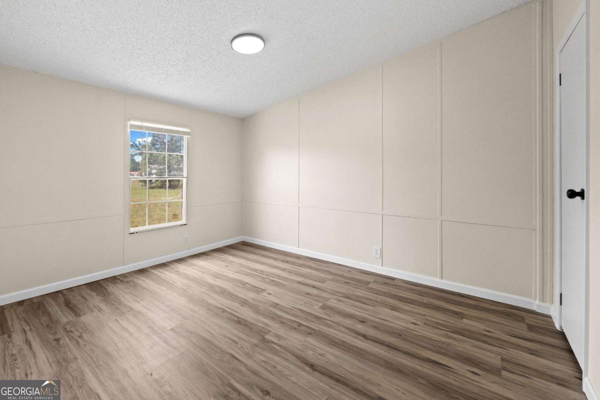 802 Allen Drive Vidalia, GA 30474 - Photo 25 of 29 a view of an empty room with wooden floor and a window