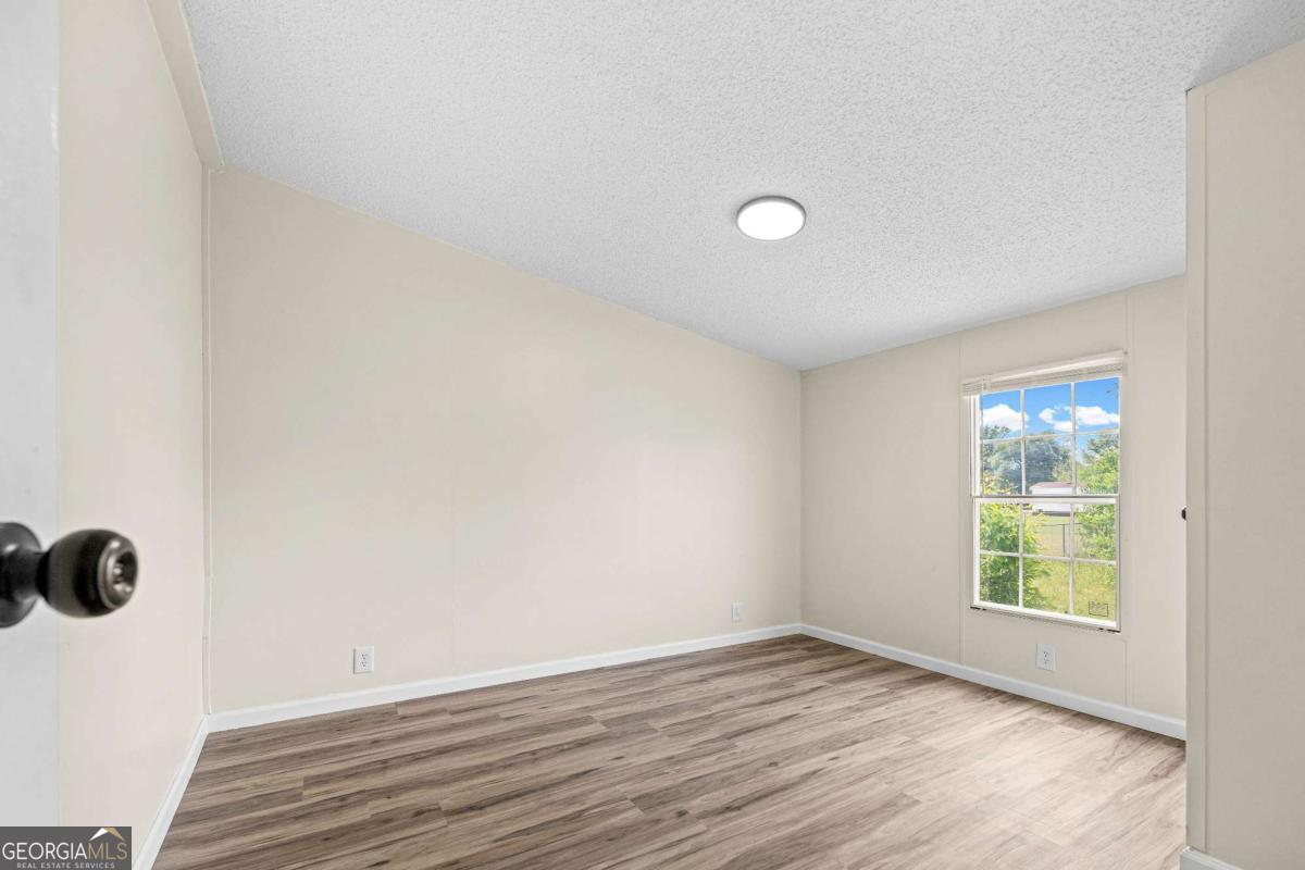 802 Allen Drive Vidalia, GA 30474 - Photo 27 of 29 an empty room with wooden floor and windows