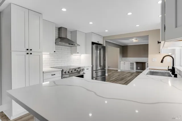 a spacious bedroom with a bed a table and potted plant with the dresser