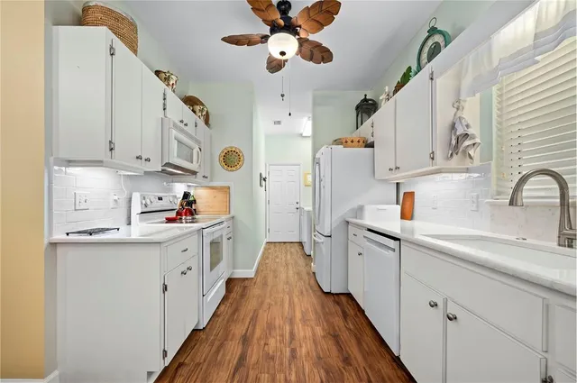 a kitchen with cabinets a sink and wooden floor