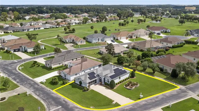 an aerial view of a house with a garden and lake view