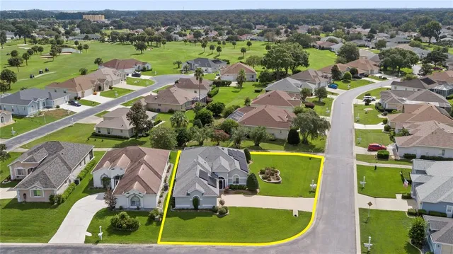 an aerial view of residential houses with outdoor space and lake view