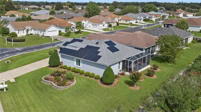 an aerial view of a house with yard swimming pool and mountain view in back