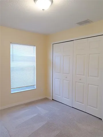 a view of a room with a ceiling fan and window