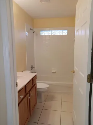 a bathroom with a granite countertop sink a toilet and shower