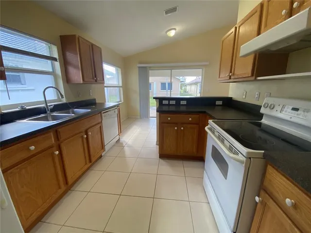 a kitchen with a stove sink and cabinets