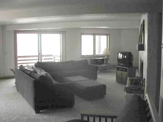 a living room with couches and a large window