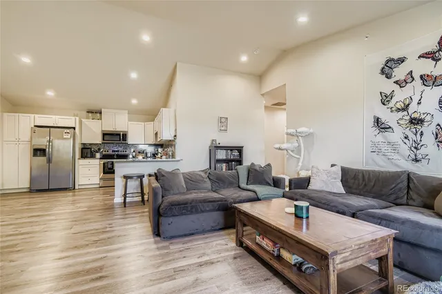 a living room with furniture and kitchen view
