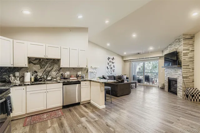 a kitchen with a sink stove cabinets and wooden floor