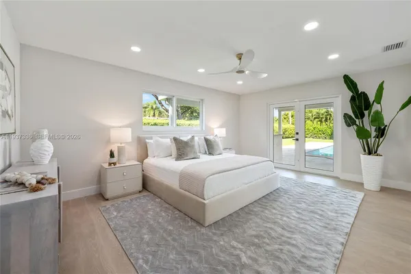 a bedroom with a large bed and a potted plant
