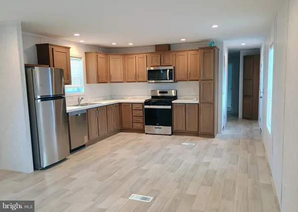 a kitchen with stainless steel appliances granite countertop a refrigerator stove top oven and sink