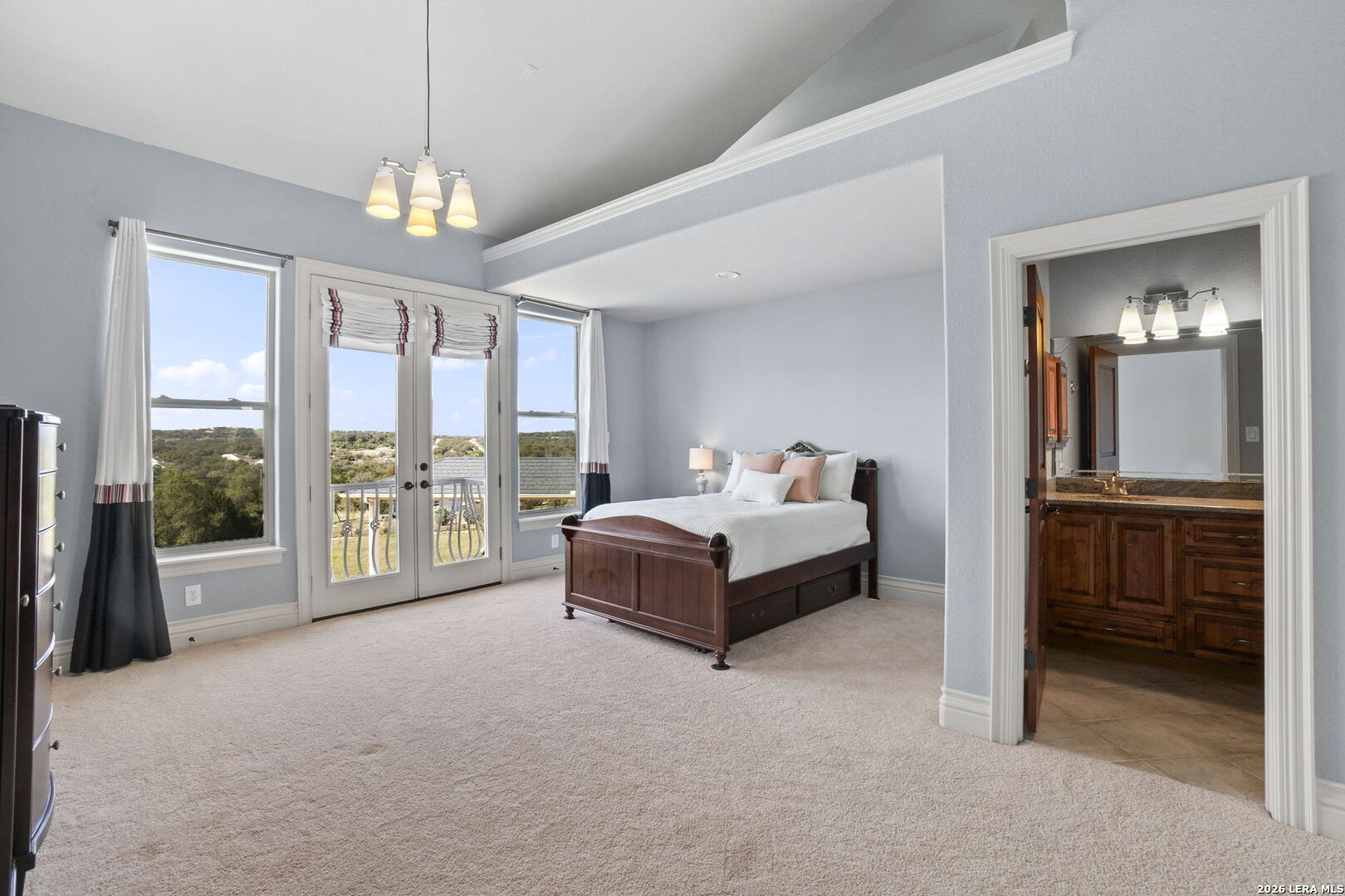 6762 Mnr Hl Road San Antonio, TX 78257 - Photo 36 of 51 a spacious bedroom with a bed and a chandelier