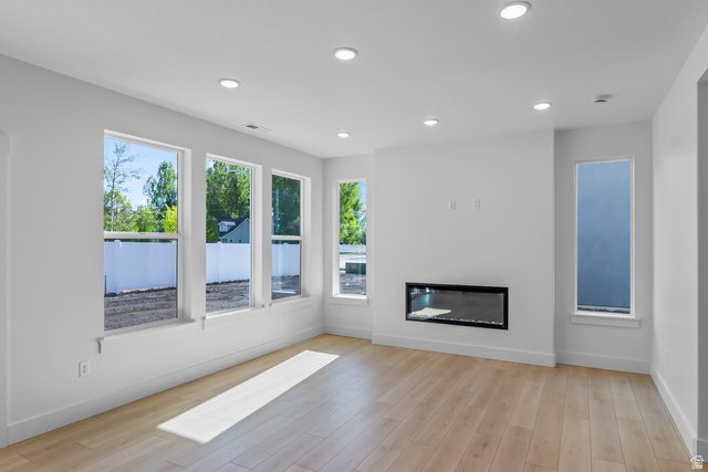 1237 West 500 South, Unit 230 Logan, UT 84321 - Photo 6 of 42 Recessed lighting illuminates an open living area featuring wood-finish flooring, a linear electric fireplace, and multiple windows