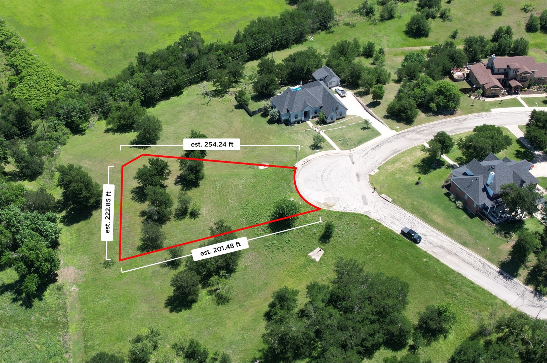 1700 Tanner Loop Taylor, TX 76574 - Photo 1 of 32 Expansive corner lot with mature trees, a gently sloping grassy terrain, and estimated dimensions of 254.24 ft, 222.85 ft, and 201.48 ft