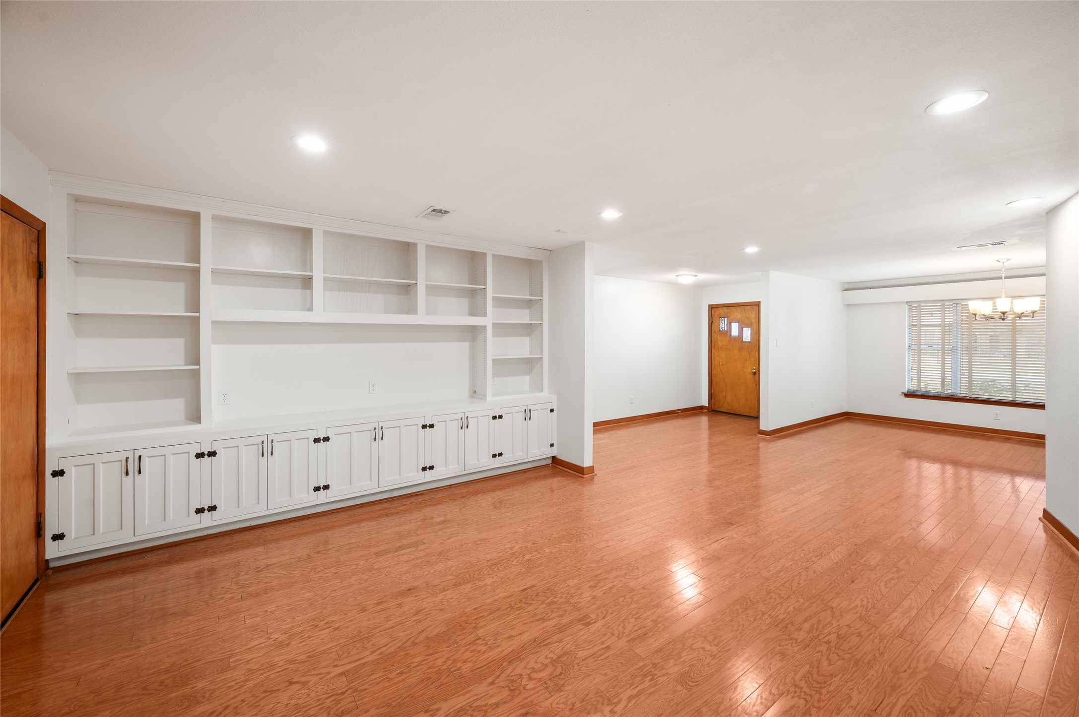 405 Hohldale Street Houston, TX 77091 - Photo 12 of 39 Spacious living room with recessed lighting, extensive built-in shelving and storage, and easy flow to the dining area and adjacent spaces.