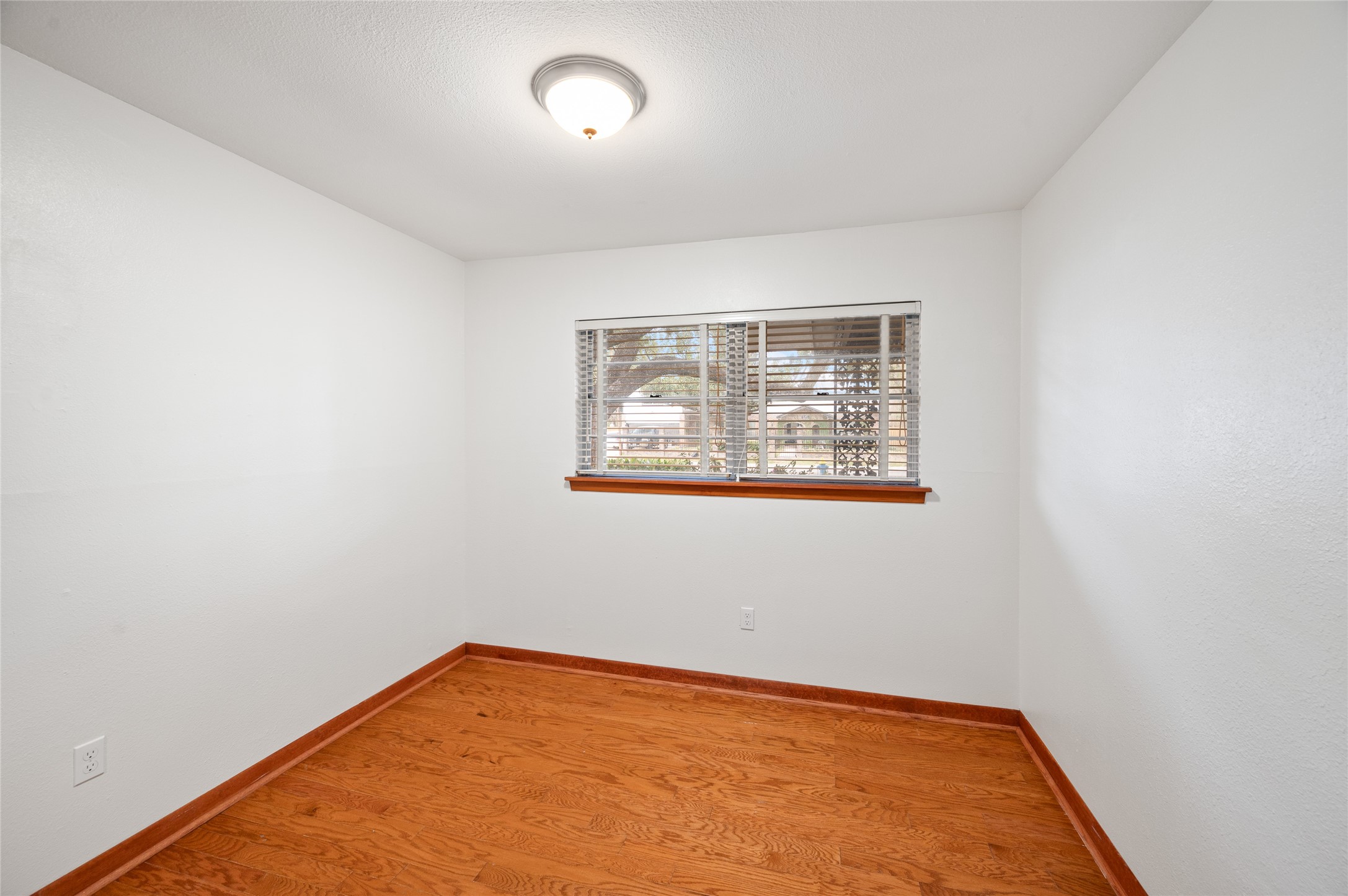 405 Hohldale Street Houston, TX 77091 - Photo 16 of 39 Secondary bedroom with wood flooring and ample natural light, suitable for a variety of uses.