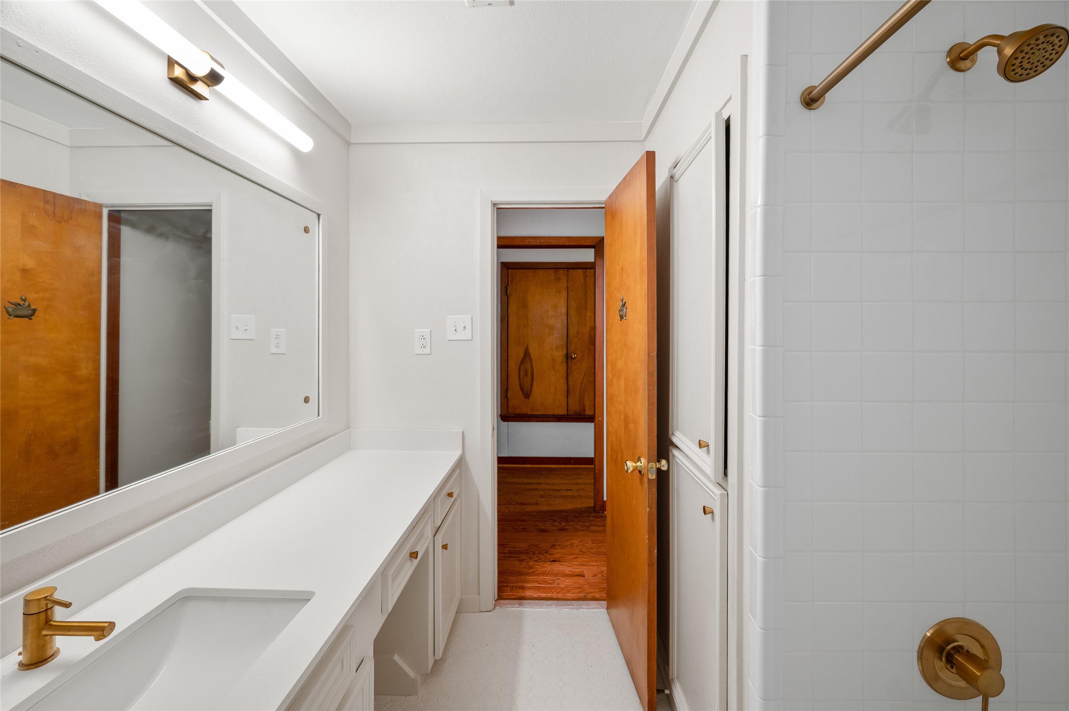 405 Hohldale Street Houston, TX 77091 - Photo 19 of 39 An alternate view of the hallway bathroom which boasts a bright ambiance with sleek fixtures, ample counter space, and a stylish shower, offering a perfect blend of functionality and modern elegance.