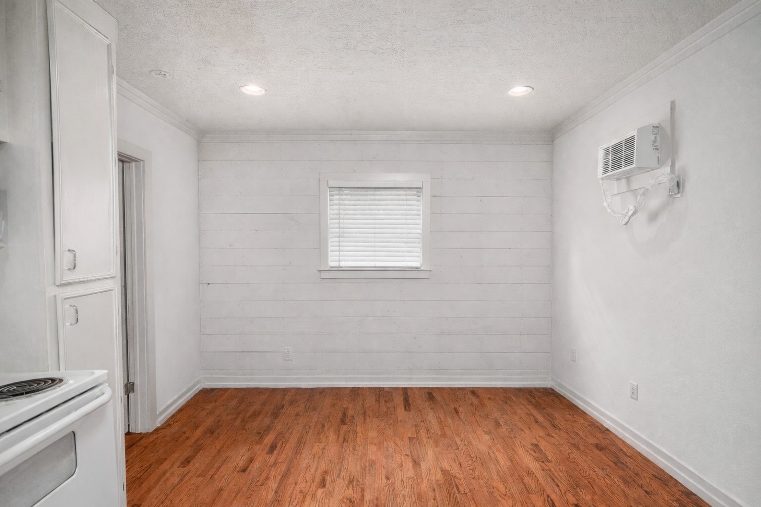 405 Hohldale Street Houston, TX 77091 - Photo 29 of 39 Experience cozy cabin charm in this inviting living room featuring warm wood floors and sleek white shiplap walls, perfect for creating your ideal retreat.