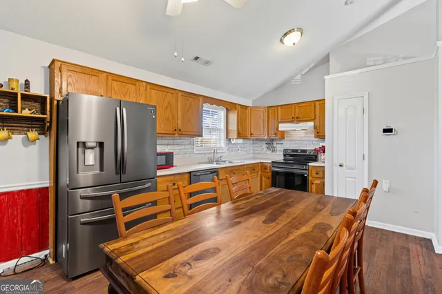 a kitchen with stainless steel appliances a refrigerator and a stove top oven