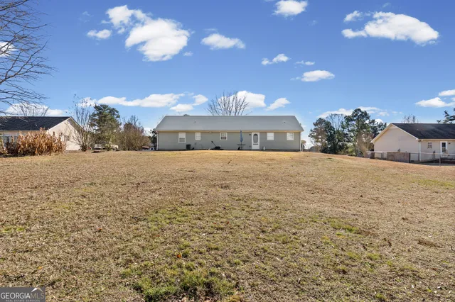 a view of a house with a yard and a large tree