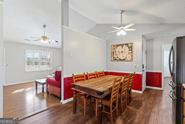 a dining room with furniture a chandelier and wooden floor