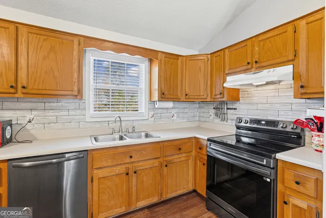 a kitchen with a sink stove and cabinets