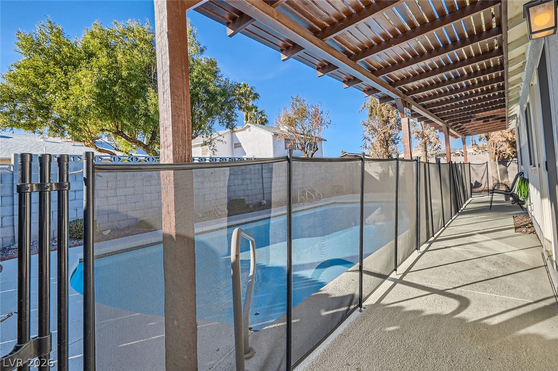 3665 Bronco Road Las Vegas, NV 89103 - Photo 24 of 28 A private pool with a protective fence and an inviting pergola for outdoor relaxation.
