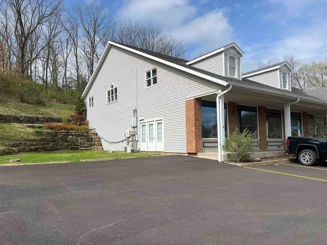 a view of a house with backyard and parking area