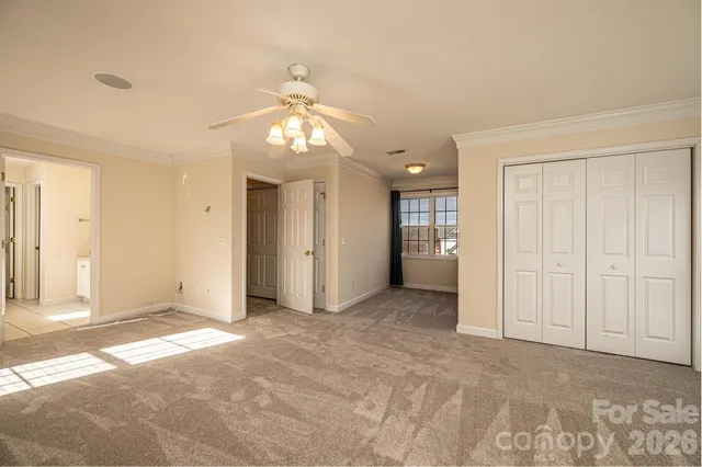 a view of a livingroom with a chandelier fan and closet area