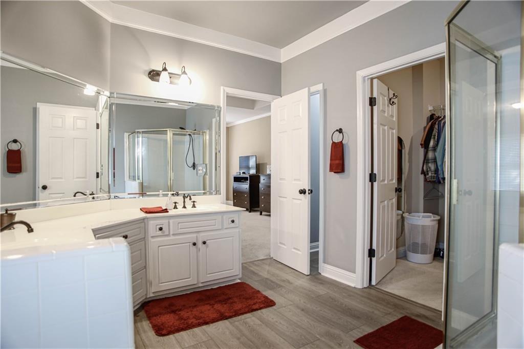 3875 Spring Manor Court Loganville, GA 30052 - Photo 23 of 23 a large bathroom with a double vanity sink a mirror and a shower