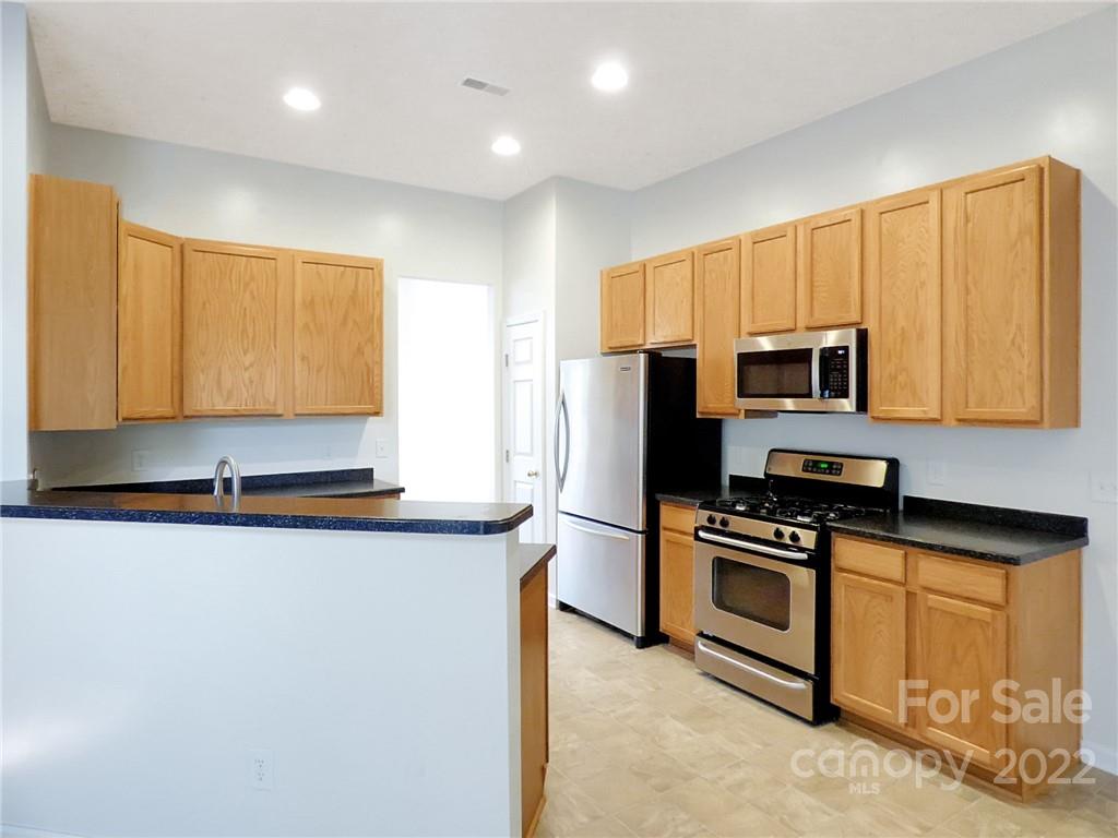 16214 Hayfield Road Charlotte, NC 28213 - Photo 4 of 10 a kitchen with stainless steel appliances granite countertop a stove a sink a microwave a refrigerator a counter space and cabinets
