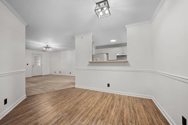 a view of empty room with wooden floor
