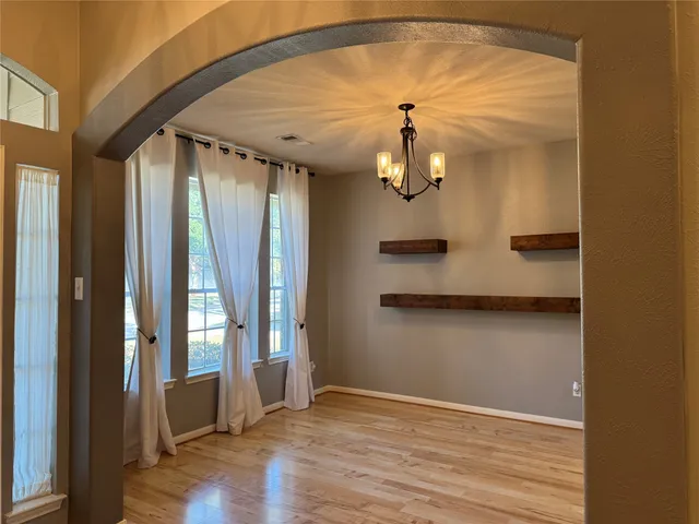 an empty room with wooden floor and door