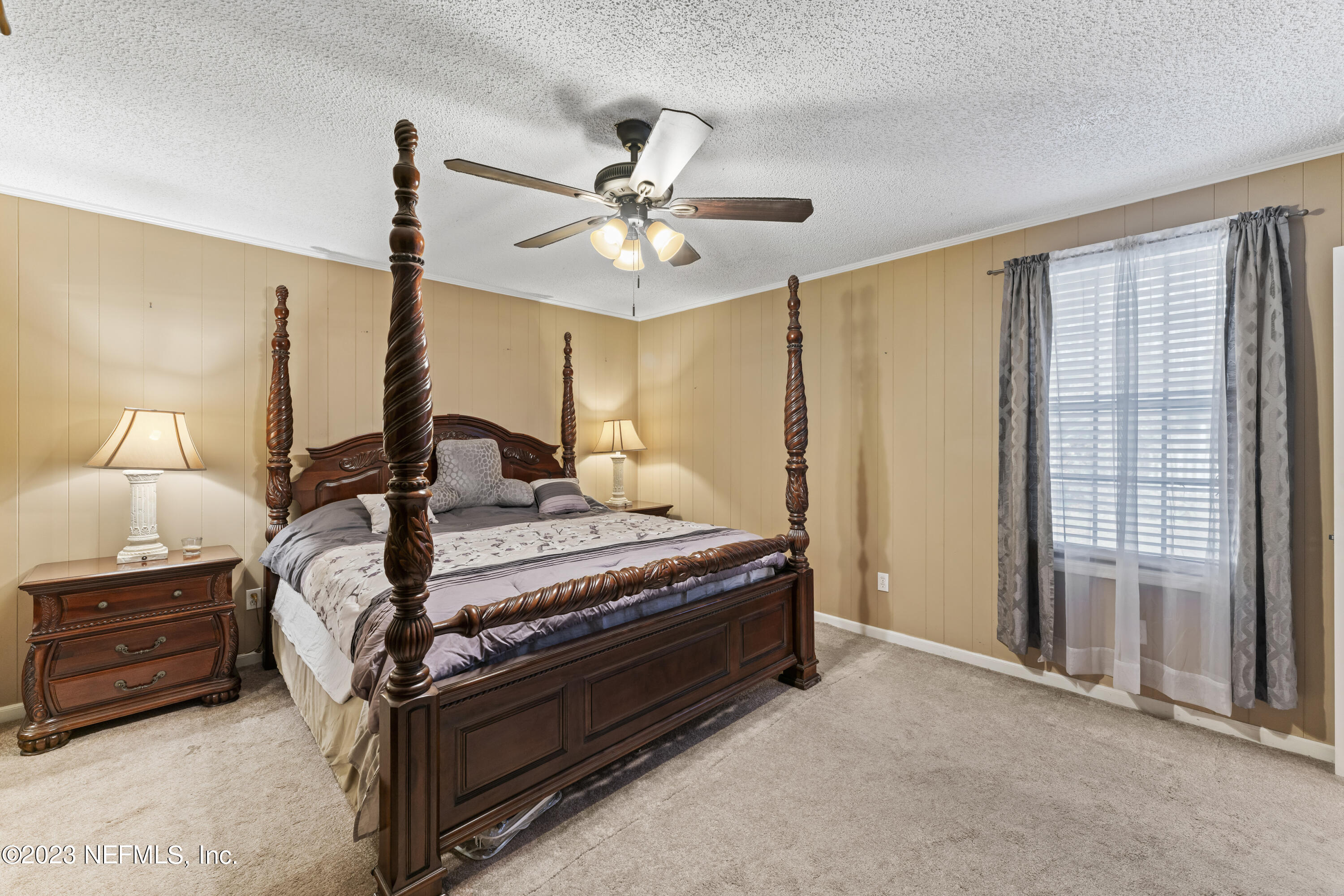 7349 Oakridge Loop Glen St. Mary, FL 32040 - Photo 24 of 56 a bedroom with a bed a chandelier and a window