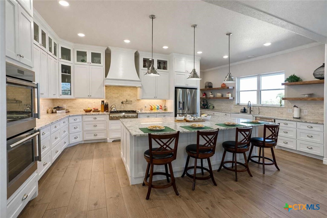705 Indian Hills Road Gatesville, TX 76528 - Photo 12 of 43 a kitchen with stainless steel appliances granite countertop a stove a sink a oven a dining table and chairs