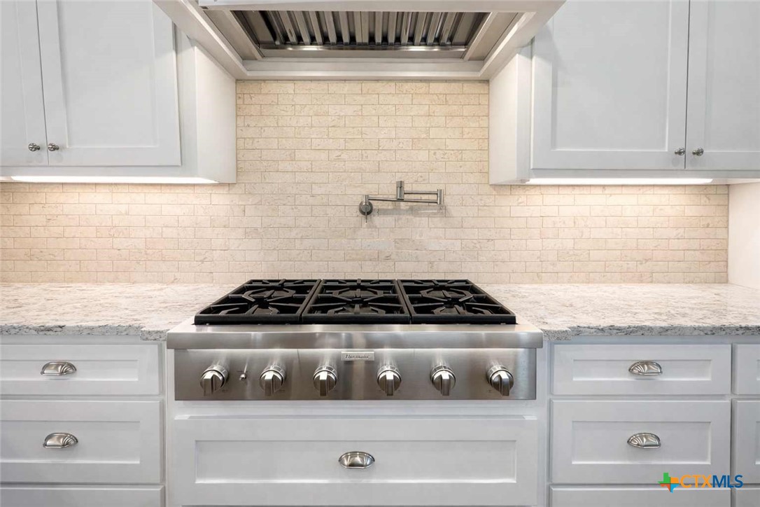 705 Indian Hills Road Gatesville, TX 76528 - Photo 15 of 43 a stove top oven sitting inside of a kitchen and granite counter tops