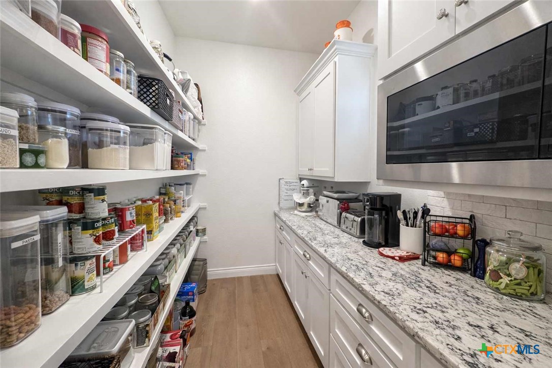 705 Indian Hills Road Gatesville, TX 76528 - Photo 17 of 43 a kitchen with stainless steel appliances granite countertop a lot of cabinets and wooden floor