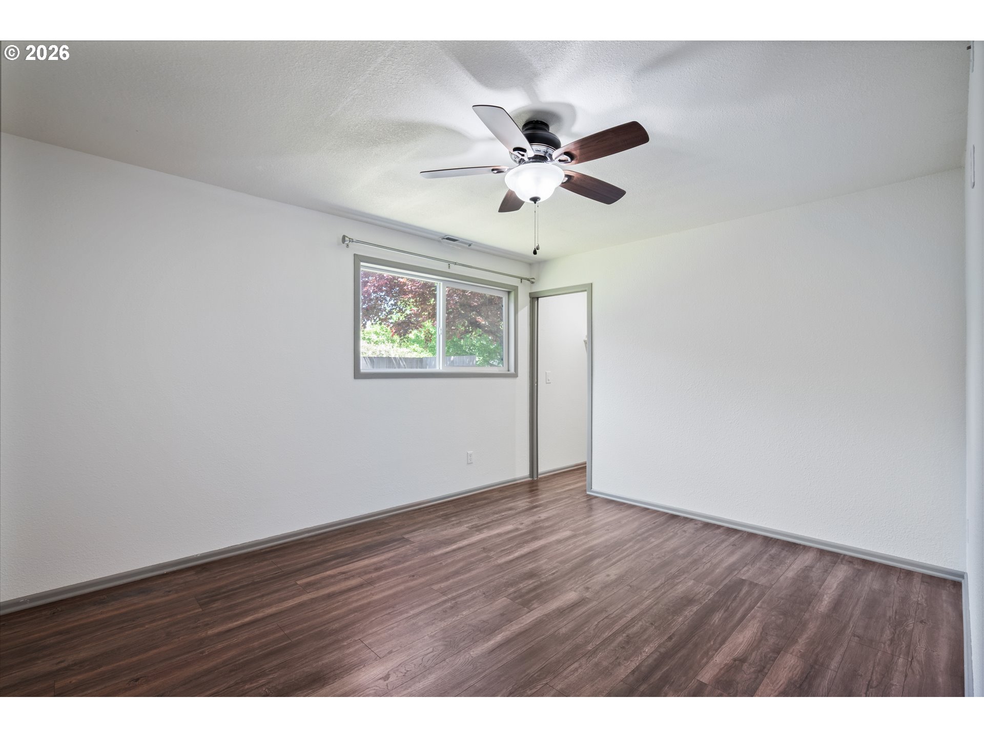 4703 Merlin Street Longview, WA 98632 - Photo 15 of 25 a view of an empty room with wooden floor and a ceiling fan