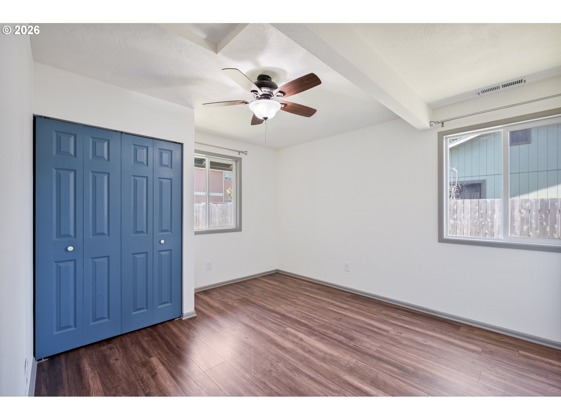 4703 Merlin Street Longview, WA 98632 - Photo 18 of 25 an empty room with wooden floor ceiling fan and windows