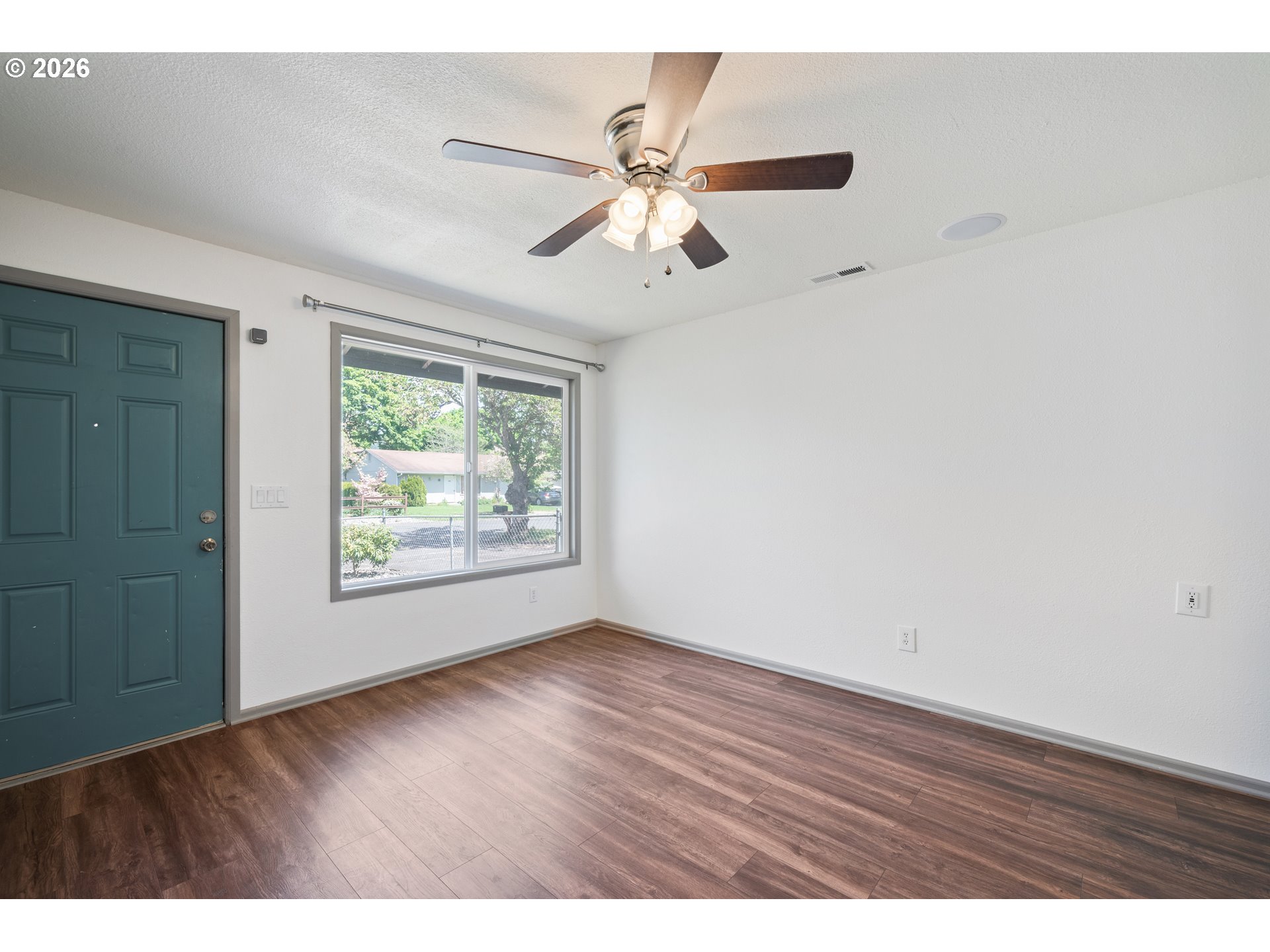 4703 Merlin Street Longview, WA 98632 - Photo 7 of 25 an empty room with wooden floor fan and windows