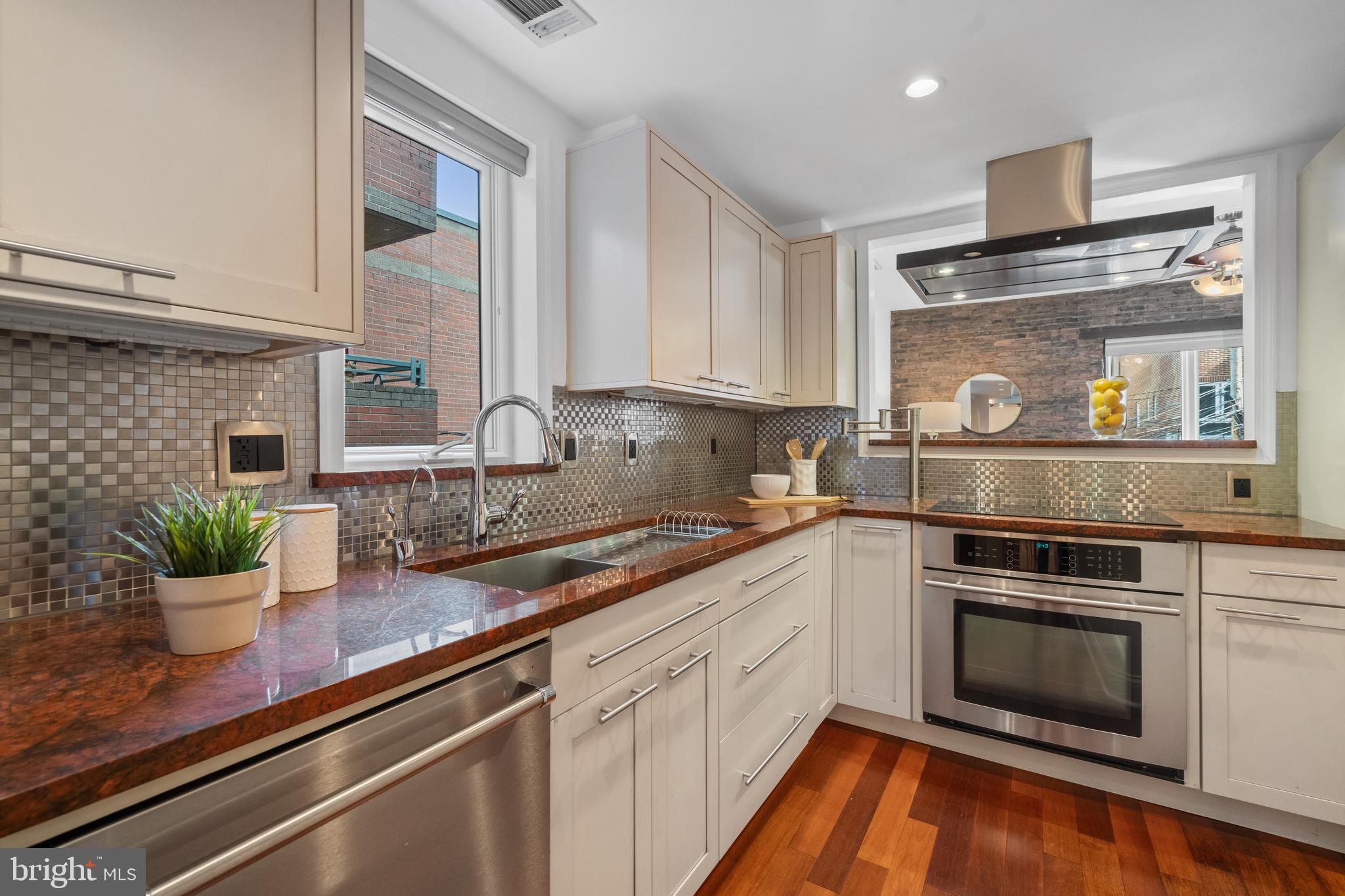 1625 Q Street Northwest, Unit 203 Washington, DC 20009 - Photo 4 of 33 a kitchen with stainless steel appliances white cabinets and a stove