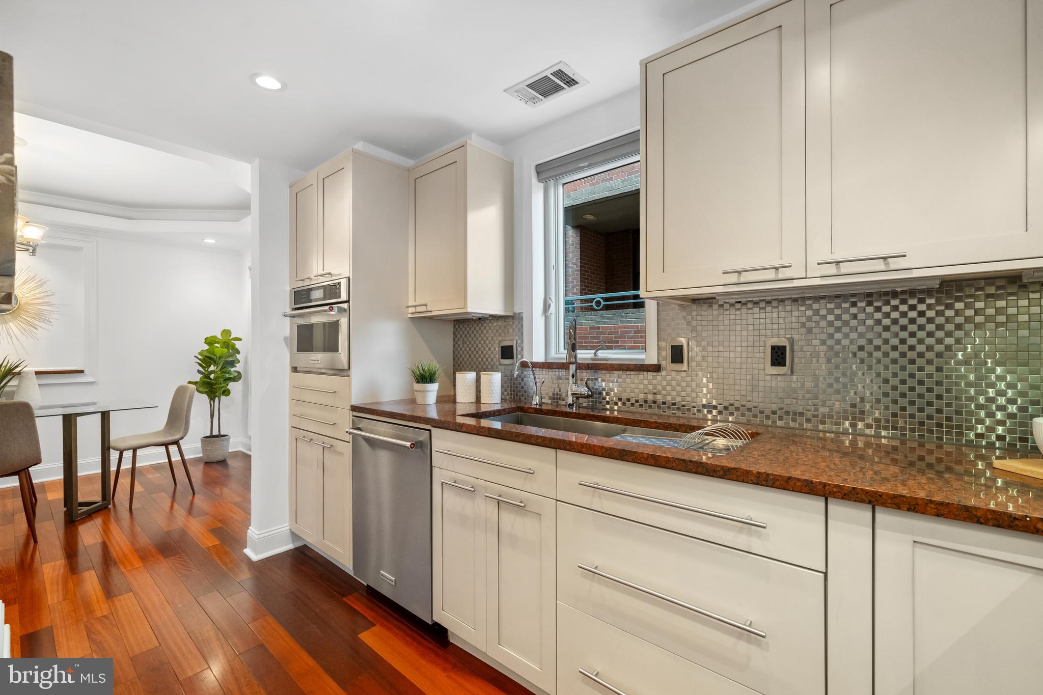 1625 Q Street Northwest, Unit 203 Washington, DC 20009 - Photo 5 of 33 a kitchen with granite countertop a sink cabinets stainless steel appliances and a wooden floor