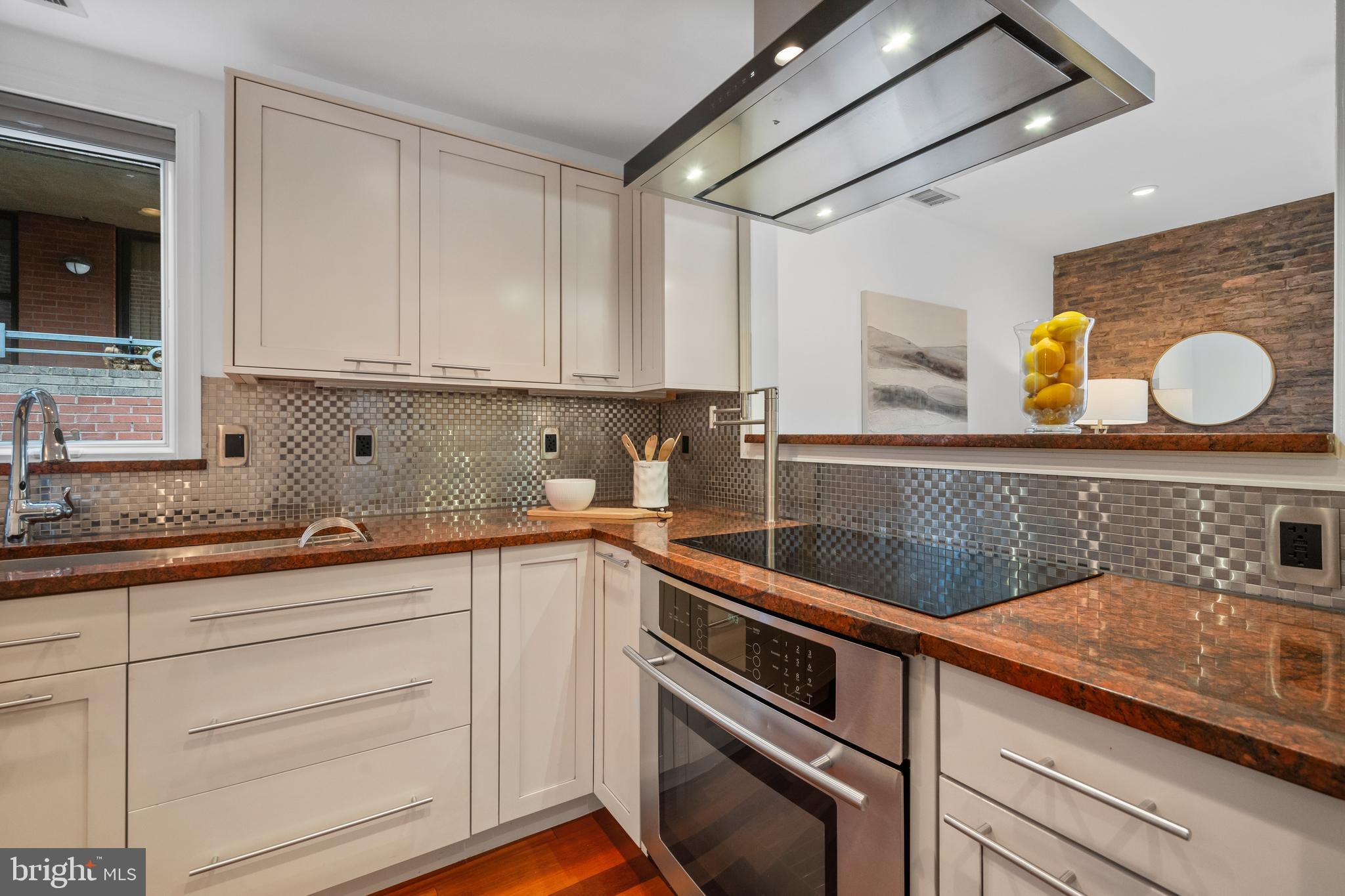 1625 Q Street Northwest, Unit 203 Washington, DC 20009 - Photo 6 of 33 a kitchen with granite countertop white cabinets and sink