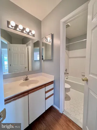 a bathroom with a granite countertop sink a large mirror and a bathtub